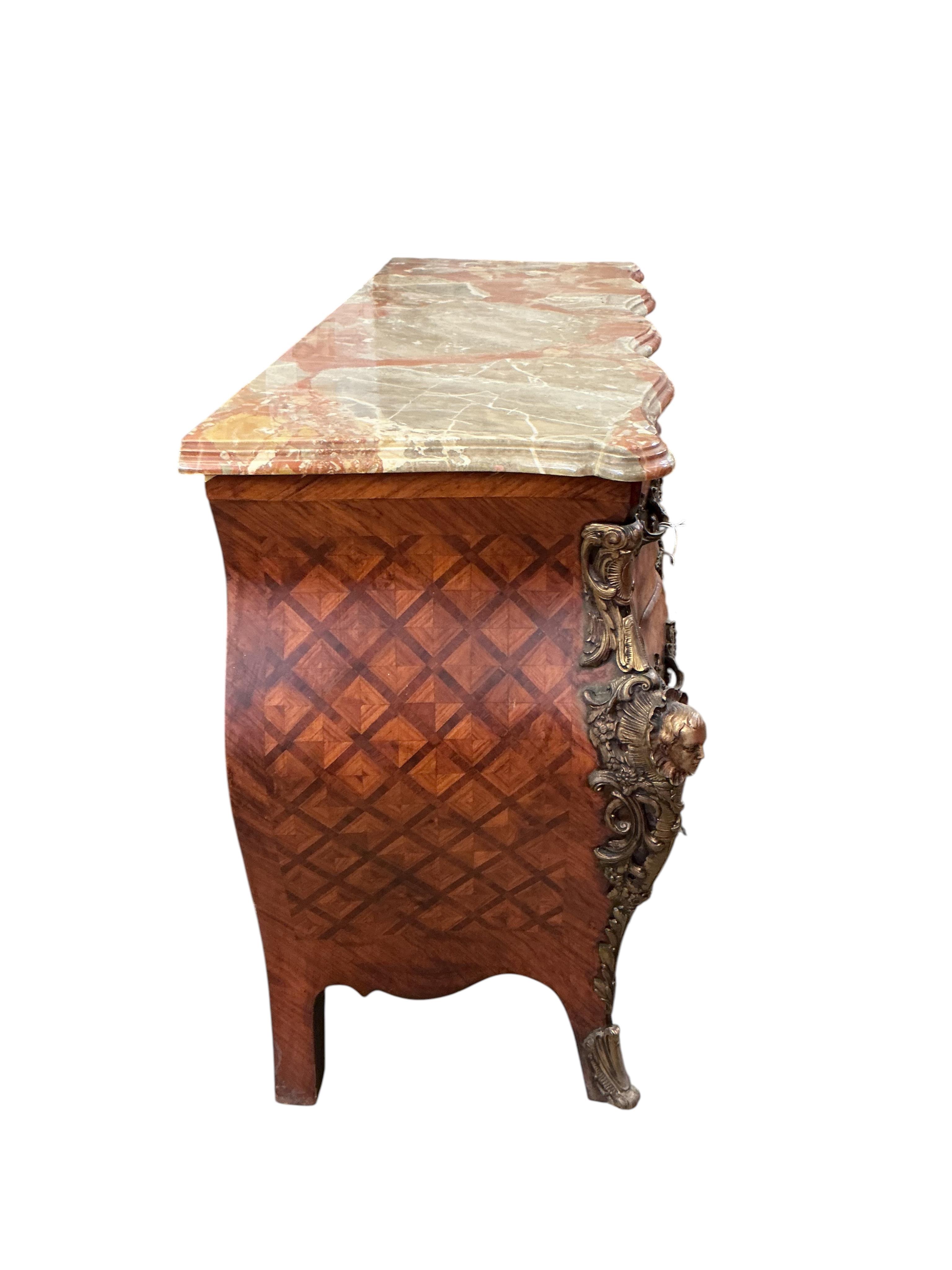 A French transitional style gilt metal mounted onyx top bombe commode, width 114cm, depth 47cm, height 88cm